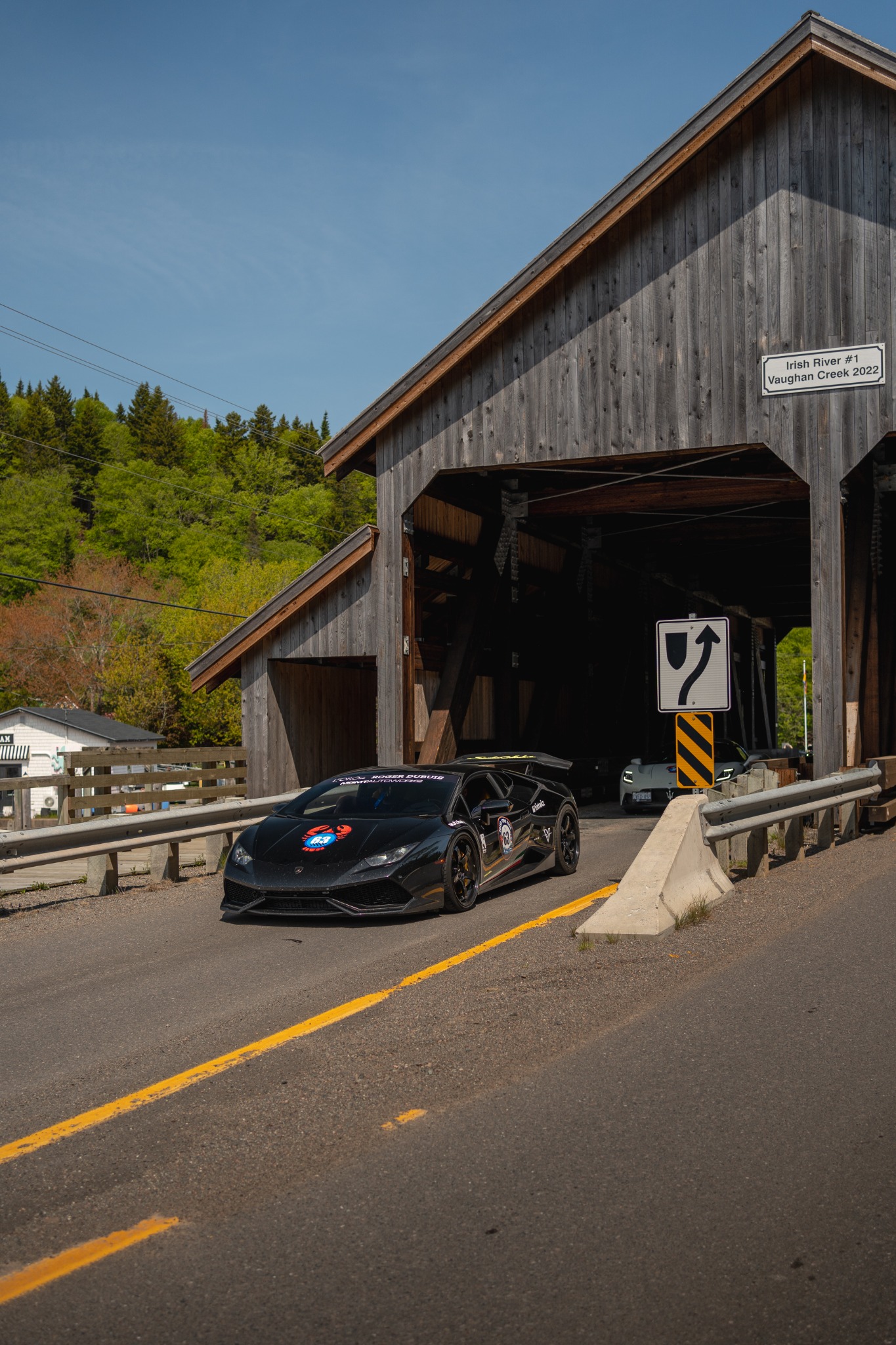 The black Huracán at a covered bridge.